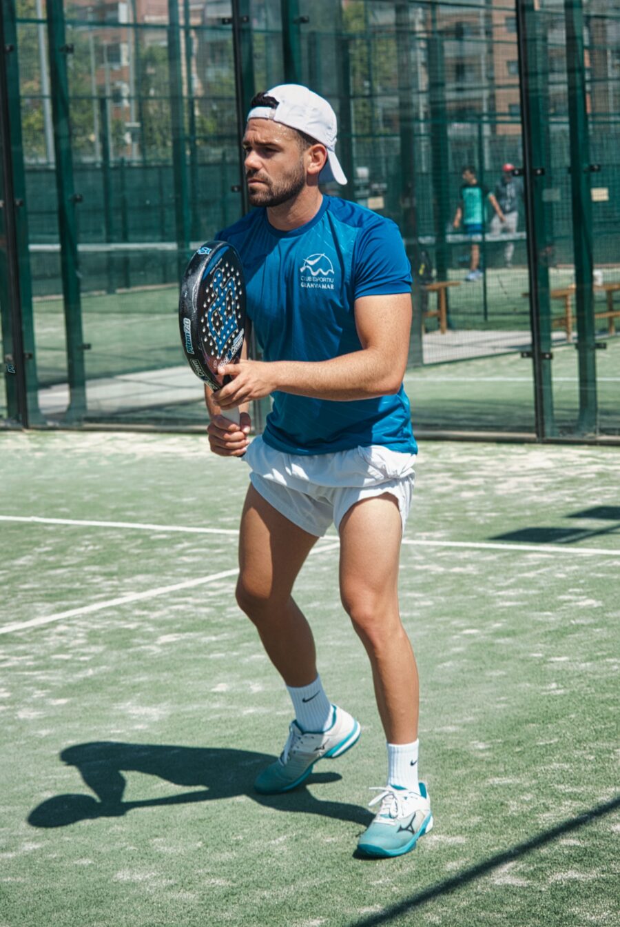 Bilden visar en person som spelar padel på en padelbana med padelrack. Nu kan du enkelt bygga padelbana och köpa padelbana, samt få bästa pris online, nu kan du enkelt modifiera din padelbana smidigt online.